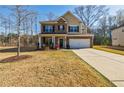 Traditional two-story home with brick and siding, a two-car garage, and a spacious front lawn at 4870 Odum View Ln, Cumming, GA 30040