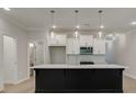 Modern kitchen featuring a dark island, white cabinets, and updated lighting at 1628 Ruskin Way, Marietta, GA 30062