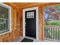 Inviting front porch with a wooden ceiling, a charming black door, and cedar shingle accents at 353 Oak Ridge Se Dr, Marietta, GA 30060