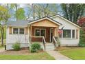 Charming home featuring a covered porch, lush lawn, fresh white siding, and detailed window trim at 353 Oak Ridge Se Dr, Marietta, GA 30060