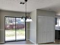 Dining area with sliding glass doors to backyard, closet, and modern lighting fixture at 4805 Kellys Mill Nw Dr, Lilburn, GA 30047