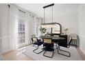 Elegant dining room with a modern chandelier, seating for six, and bright windows with sheer curtains at 966 Laurel Springs Sw Ln, Marietta, GA 30064