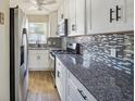 Well-lit kitchen featuring stainless steel appliances, granite countertops, white cabinetry and tile backsplash at 2391 Cove Rd, Lithonia, GA 30058