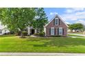Charming two-story home with a brick facade, green lawn, and mature shade tree at 2650 Hamilton Chase Run, Buford, GA 30519
