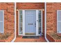 Close-up of the home's front entrance, featuring a stylish door, sidelights, and brick walkway at 1085 Grace Hadaway Ln, Lawrenceville, GA 30043