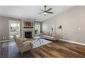 Bright living room with fireplace, modern furniture, ceiling fan, and hardwood flooring at 11370 Ridge Hill Dr, Alpharetta, GA 30022