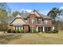 Traditional brick home with a manicured lawn, black shutters, and neutral trim at 7090 Blue Sky Drive, Locust Grove, GA 30248