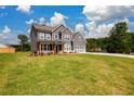 Spacious front lawn of a gray two-story home featuring a covered entryway and attached garage at 8245 Dawson View Way, Cumming, GA 30028