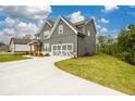 Side view of a modern gray home featuring a two-car garage and expansive lawn at 8245 Dawson View Way, Cumming, GA 30028