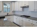 Granite countertops and stainless appliances complement the white cabinetry in this kitchen at 8245 Dawson View Way, Cumming, GA 30028