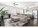Bright open-concept living room with hardwood floors, modern sofa, and stainless steel appliances at 3905 Danube Ln # 215, Atlanta, GA 30339