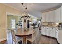 Cozy dining area featuring a round wooden table, white cabinets, and stylish lighting, perfect for Gathering meals at 865 Mount Katahdin Trl, Johns Creek, GA 30022