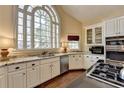 Bright kitchen featuring granite countertops, white cabinets, stainless steel appliances, and a large window at 865 Mount Katahdin Trl, Johns Creek, GA 30022
