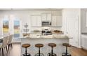 Modern kitchen with granite countertops, stainless steel appliances, and island with seating at 354 Friendship Oak Way, Hampton, GA 30228