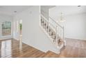 Bright entryway with hardwood floors and white staircase with banister at 6244 Marbut Farms Trl, Lithonia, GA 30058