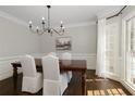 Inviting dining room features a wooden table, white chairs, and ample natural light at 290 Coles Hill Ct, Johns Creek, GA 30022
