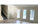 Open-concept living room with tile floors, entry door, and stairs leading to the second floor at 849 Cadet Nw Ct, Lilburn, GA 30047