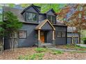 Charming exterior featuring a covered porch with stone accents and a natural wood door at 1890 Spalding Dr, Atlanta, GA 30350