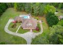 Estate featuring a beautiful pool and circular driveway surrounded by mature trees and landscaping at 5040 Fawn Valley Dr, Loganville, GA 30052