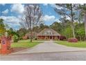 Charming home with a welcoming front porch and a long driveway, set amidst mature trees at 5040 Fawn Valley Dr, Loganville, GA 30052