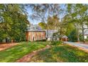 Two-story brick and siding house with mature trees and a well-manicured lawn at 1285 Wesley Nw Pl, Atlanta, GA 30327