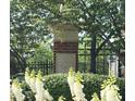 Landscaped community sign for Olde Ivy Vinings Estates with brick base and black iron fence at 4955 Ivy Ridge Se Dr # 404, Atlanta, GA 30339