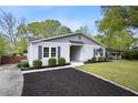 Charming single-story home with a tidy lawn, manicured shrubbery, long driveway, and tasteful exterior paint at 1251 Pierce Se Ave, Smyrna, GA 30080