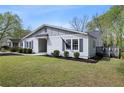 Charming home featuring a well-manicured lawn, lush landscaping, and a side deck perfect for enjoying the outdoors at 1251 Pierce Se Ave, Smyrna, GA 30080