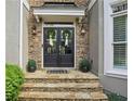 Elegant front door with stone surround, decorative wreaths, and covered entryway at 2283 Edgemere Lake Cir, Marietta, GA 30062