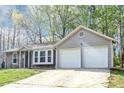 Exterior of a light grey home with two-car garage and beautiful front lawn at 5477 Hedgeflower Ct, Stone Mountain, GA 30088