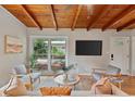 Cozy living room with a wood beam ceiling, hardwood floors, and a view to the carport at 3185 Laventure Dr, Chamblee, GA 30341