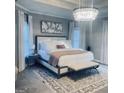 Bright main bedroom with a large bed, beautiful chandelier and soft colors at 3510 Donegal Way, Snellville, GA 30039