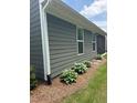 Exterior of home features gray siding and a garden alongside the house at 63 Aspen Way, Dallas, GA 30157