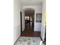 Elegant entryway showcasing hardwood floors, wainscoting, and an arched opening to the living spaces at 63 Aspen Way, Dallas, GA 30157