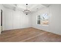 Formal dining room with wainscoting, chandelier, hardwood floors, and large window providing ample natural light at 6710 Grayland Dr, Douglasville, GA 30135