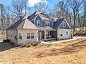 Attractive home showcasing stone and siding, complemented by a well-maintained lawn and mature trees at 6710 Grayland Dr, Douglasville, GA 30135