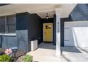 Inviting front entrance with yellow door, covered porch, and elegant architectural details at 4064 Comanche Dr, Tucker, GA 30084