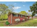 This brick home has black shutters, colorful landscaping, and a lush green lawn, presenting a welcoming curb appeal at 4290 Chestnut Grove Ln, Austell, GA 30106