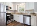 Updated kitchen with stainless steel appliances, granite countertops, and white cabinets at 5052 W Mountain St, Stone Mountain, GA 30083