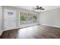 Bright living room featuring wood floors, large windows, and a modern ceiling fan at 5052 W Mountain St, Stone Mountain, GA 30083