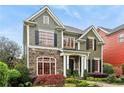 Charming two-story home with stone accents, red framed windows, lush landscaping and inviting curb appeal at 963 Manor Parc Dr, Decatur, GA 30033