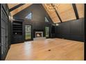 Elegant living room with black walls, a wood ceiling, built-in bookshelves, and a cozy fireplace at 1122 Manning Farms Ct, Atlanta, GA 30338