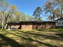 Expansive backyard featuring a brick home with outdoor seating and lush greenery at 4063 Windsor Castle Way, Decatur, GA 30034