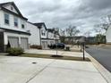 View of street showing townhomes with two car parking, landscaping, and sidewalks at 6125 Langdon Way, Cumming, GA 30028