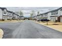 Street view showing townhomes with landscaping and sidewalks in the community at 6125 Langdon Way, Cumming, GA 30028
