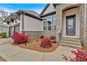 Inviting front entrance with brick accents, landscaped bushes, and a gray front door at 114 Montgomery Ln, Villa Rica, GA 30180