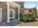 Welcoming front porch with white columns and a decorative front door, framed by manicured landscaping at 3642 Sunbridge Dr, Snellville, GA 30039