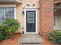 Welcoming front entrance featuring a black door, brick accents, and lush landscaping at 111 Riverstone Commons Cir, Canton, GA 30114
