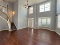 Inviting living room featuring hardwood floors, staircase, and soaring ceilings at 3354 Preserve Run Trl, Loganville, GA 30052