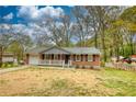 Charming one-story brick home with a welcoming front porch and a well-maintained lawn at 7535 Asbury Dr, Riverdale, GA 30274